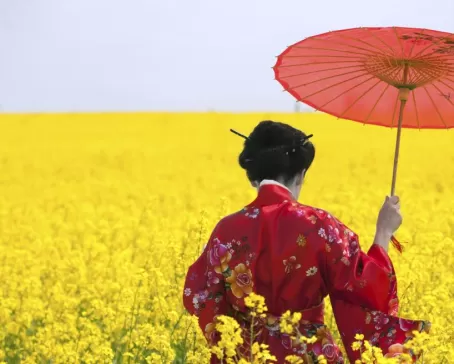 A young woman walks through a field of flowers