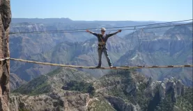A traveler crossing a bridge over Copper Canyon.