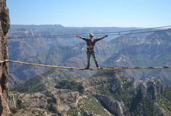 A traveler crossing a bridge over Copper Canyon.