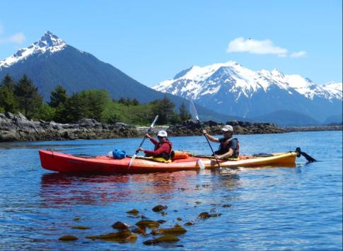 A couple kayaking through the pristine waters of Alaska