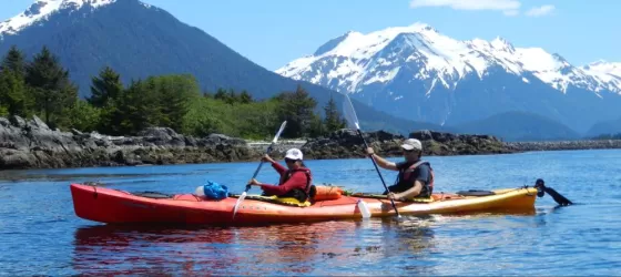 A couple kayaking through the pristine waters of Alaska
