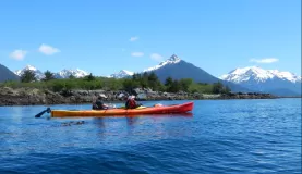 A couple kayking through Alaskan waters on a beautiful day