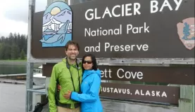 A couple poses at the entrance to Glacier Bay National Park