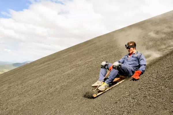 A traveler sand boards down the Cerro Negro Volcano.