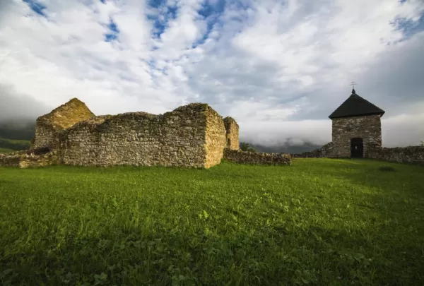 A building ruin amongst a green Slovakia landscape.