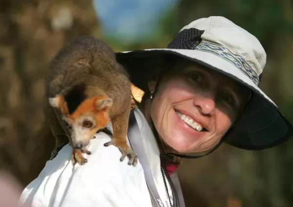 A traveler get up close and personal with a crowned lemur.
