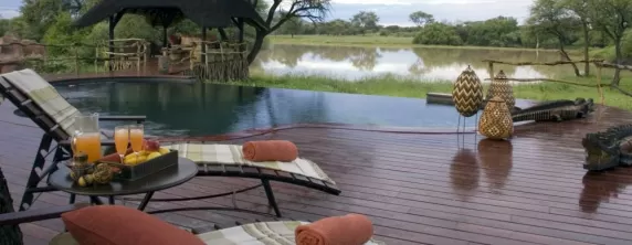 Relax by the pool and enjoy a refreshing drink at the Okonjima Bush Camp