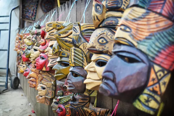 Traditional masks of Chiapas line a wall.
