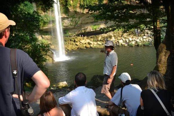 A guide informs visitors about the beautiful Misol-Ha waterfall.