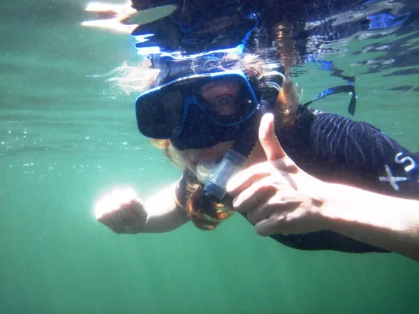 A snorkeler giving a thumbs up for a great time.