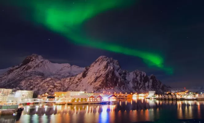 The mystical northern lights dance over a small Norwegian town