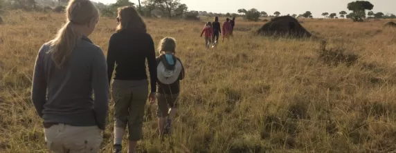 A young family walks through the African landscape