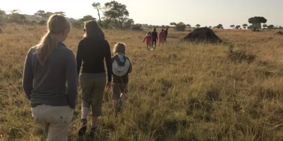 A young family walks through the African landscape