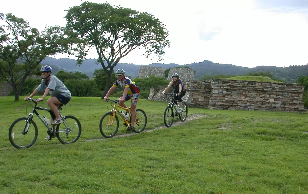 Several travelers bike through ruins of Guatemala