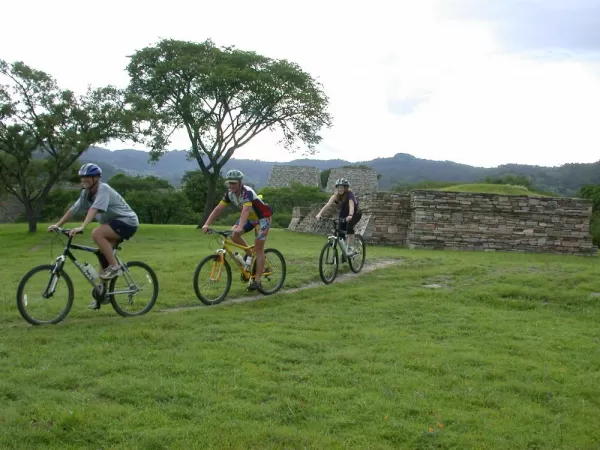 Several travelers bike through ruins of Guatemala
