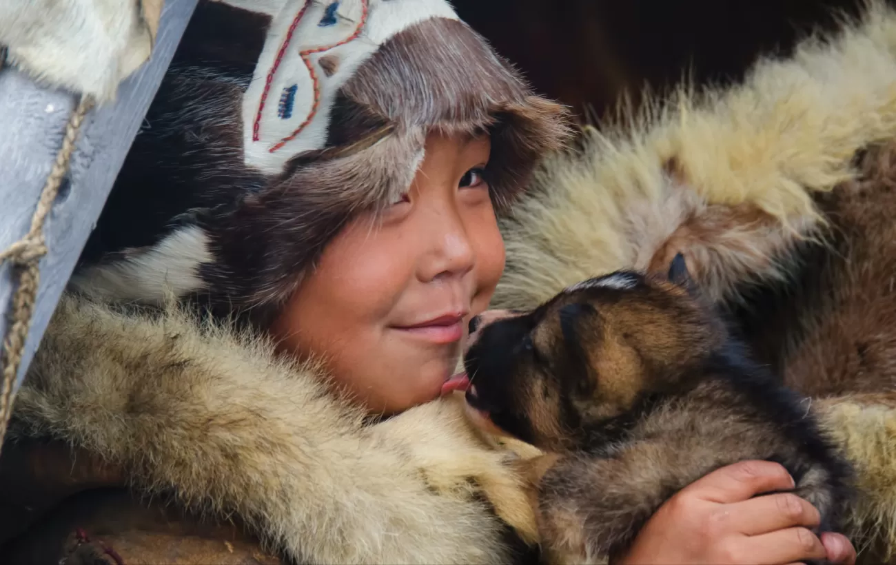 A Chukchi child holds a pup