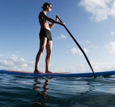 A young woman explores via Stand Up Paddleboard (SUP)