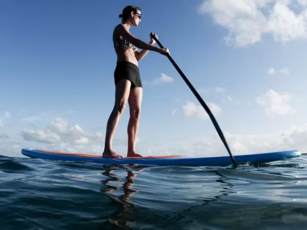 A young woman explores via Stand Up Paddleboard (SUP)